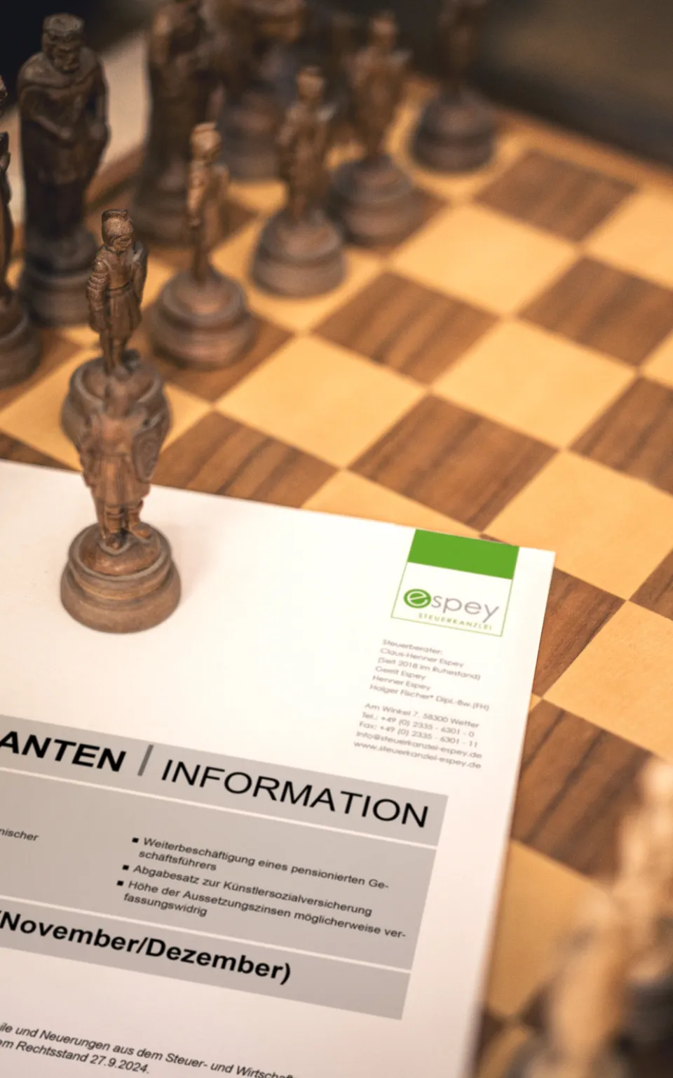Auf einem Schachbrett liegt eine Mandanteninformation zum Lesen bereit.